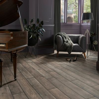 elegant Corpus Christi living room with luxury vinyl plank floors, green upholstered chair, and piano